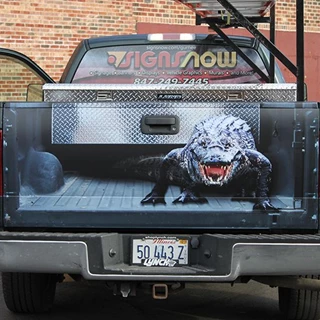 Truck tailgate with image applied to look like tailgate is off and there is a menacing alligator looking back at you.