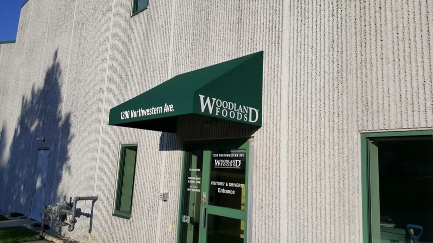 Fabric awning above doorway at Woodland Foods manufacturing facility in Gurnee, IL