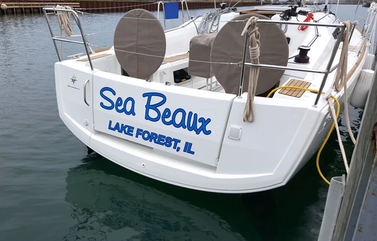 oat name lettering and hailing port applied to sail boat in two colors