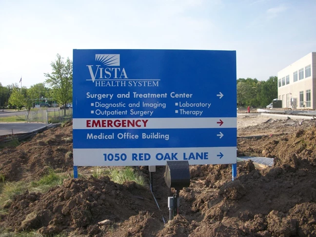 Post and panel sign with directions for hospital during construction